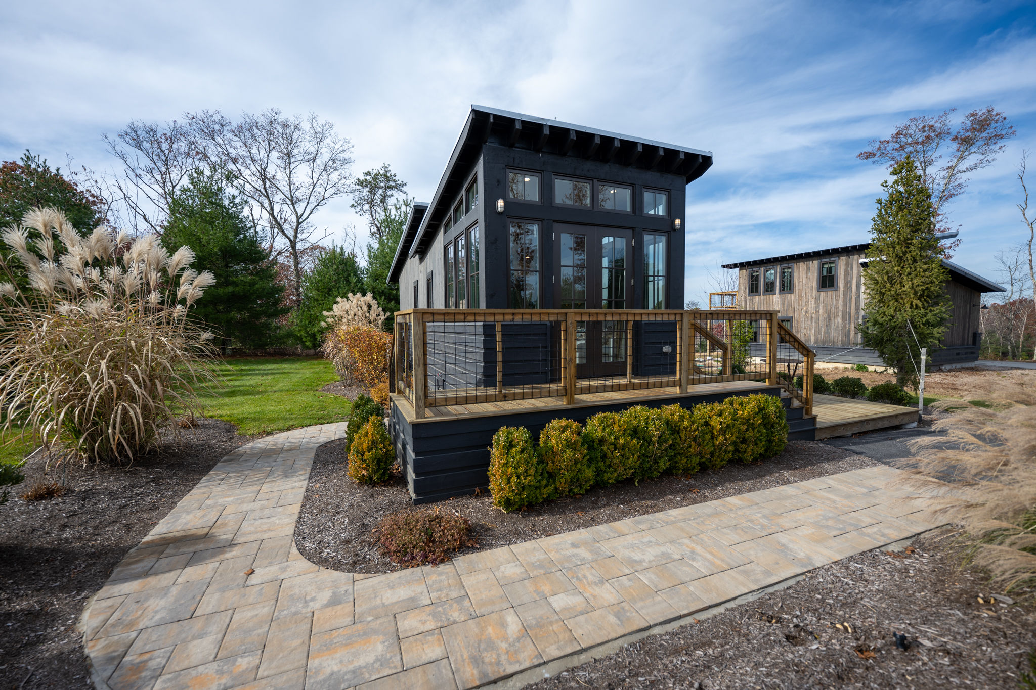 image This stylish tiny home sits amid beautifully manicured gardens, offering a peaceful retreat in a serene setting.