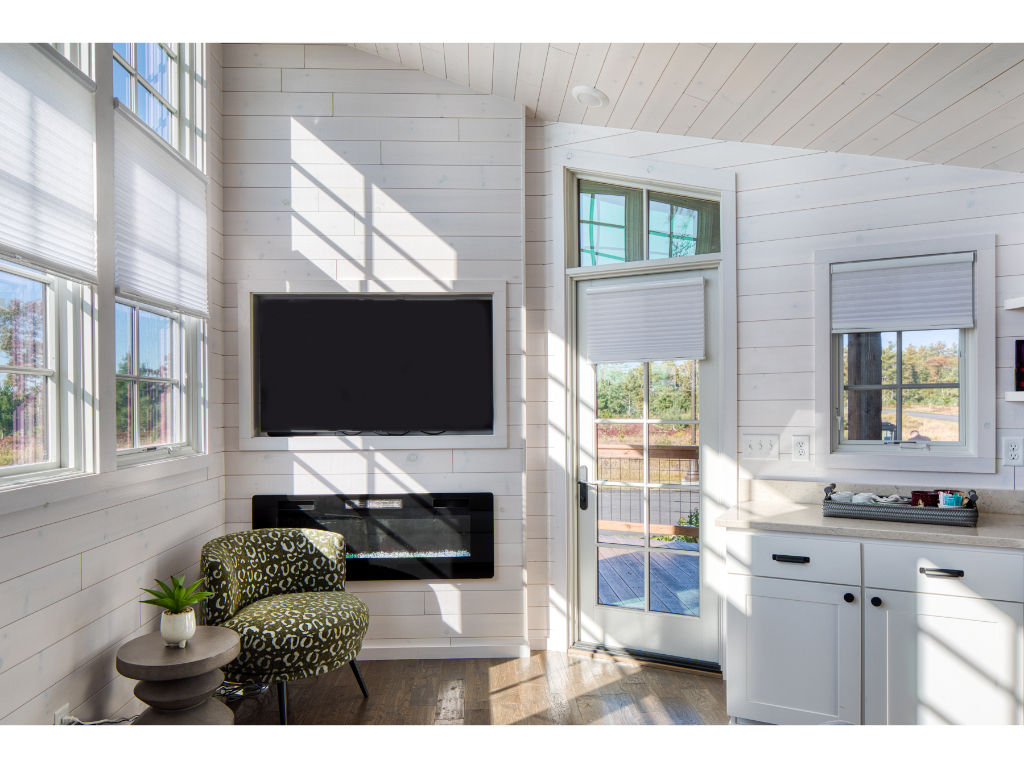 image This cozy living space features large windows that let in natural light and offer a picturesque view of the garden.