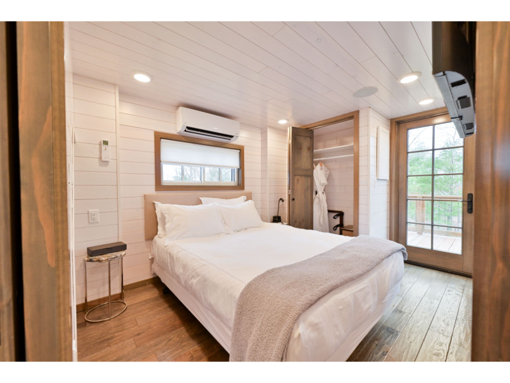 image Relax peacefully in the well-appointed bedroom, featuring large windows that frame the picturesque outdoor scenery.