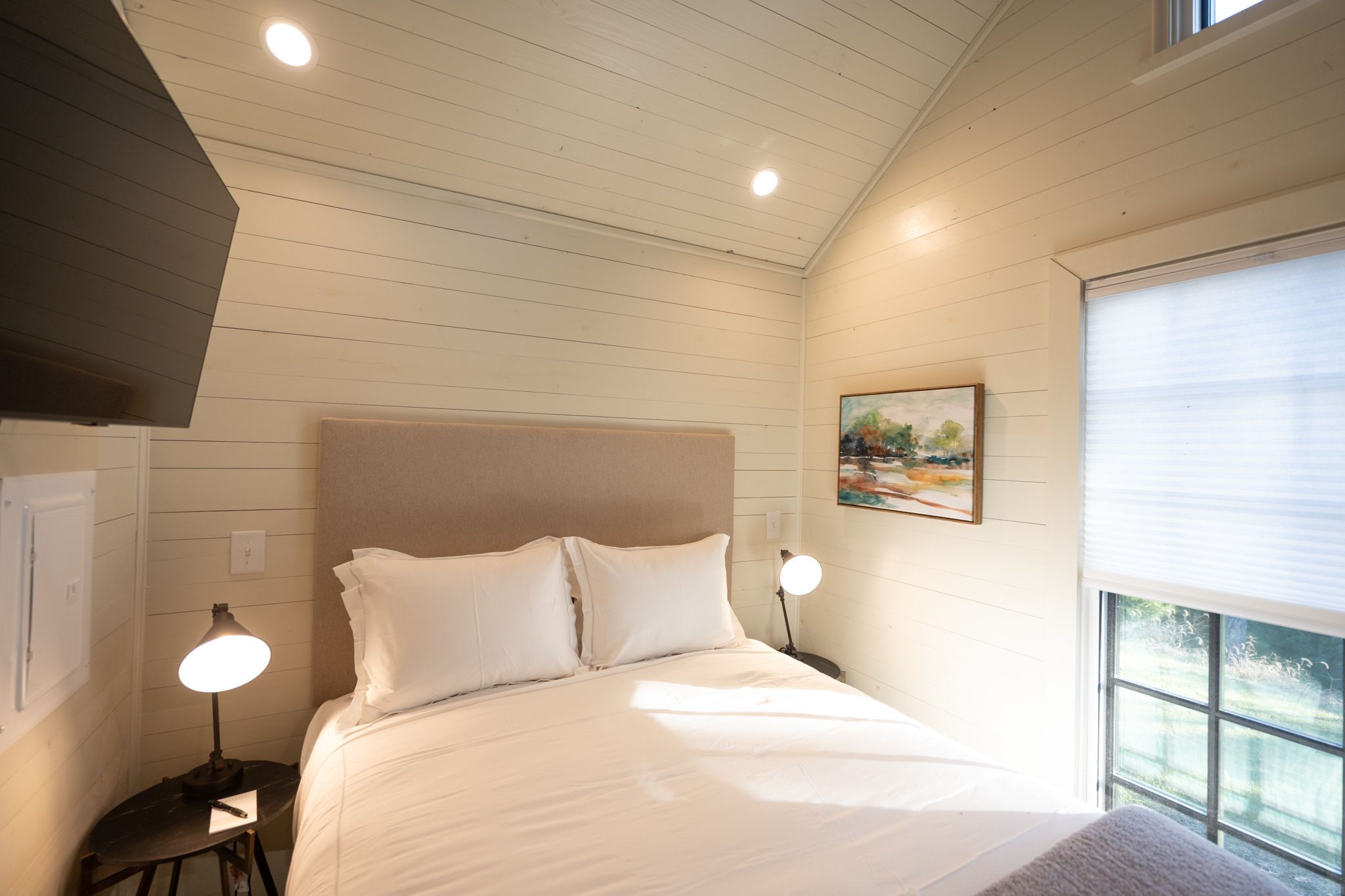 image This sunlit bedroom features large windows and stylish decor, offering a serene space to rest and recharge.