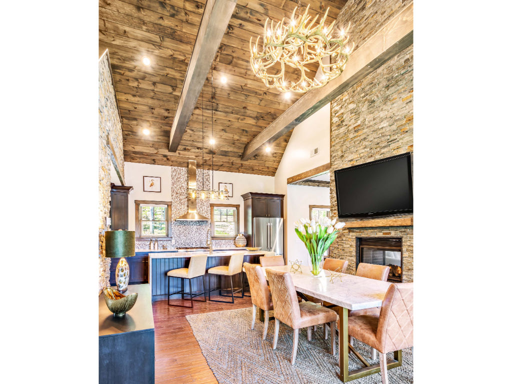 image  Elegant dining area with rustic charm, featuring a grand chandelier and exposed beam ceilings for a luxurious dining experience.