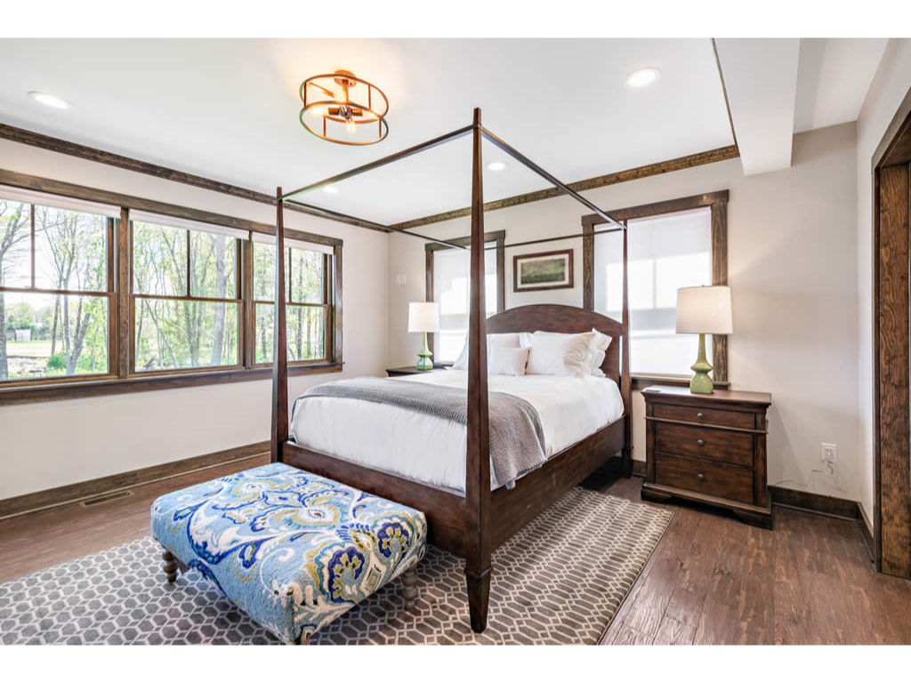 image Spacious and inviting bedroom with a stylish four-poster bed, large windows, and tasteful decor, offering a serene retreat.