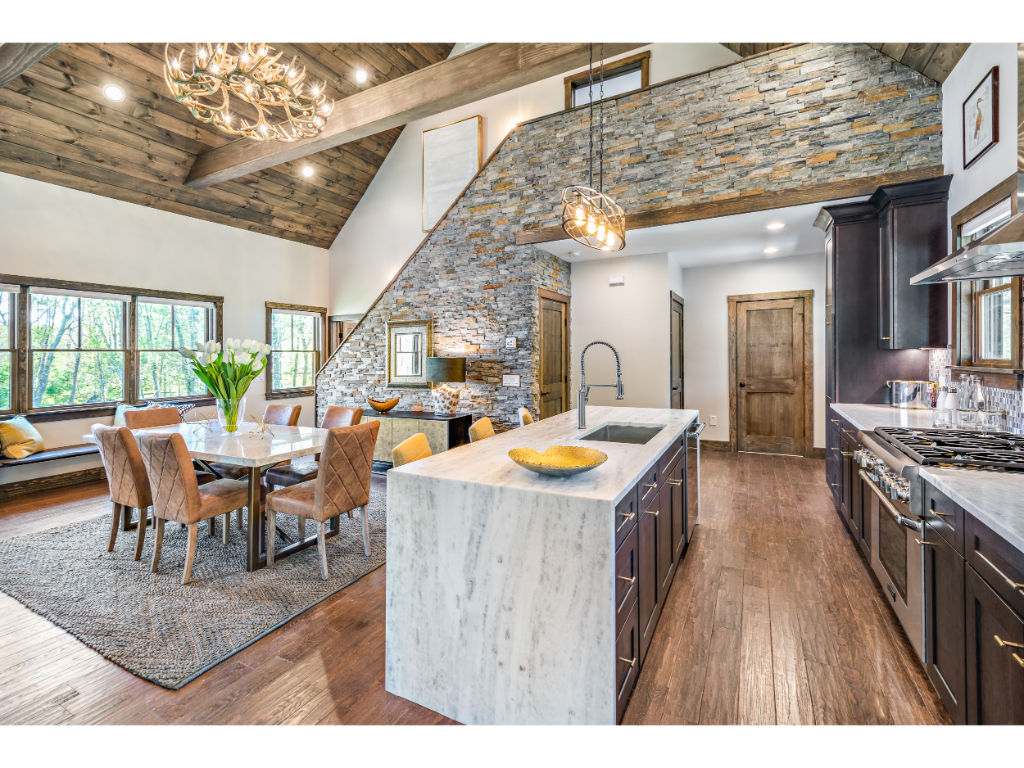 image Stunning kitchen and dining area with vaulted ceilings, exquisite lighting, and a perfect blend of rustic and modern design elements.