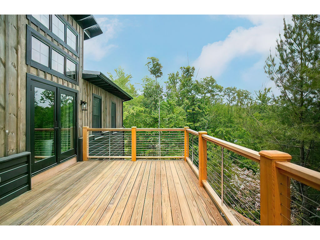 image Expansive deck at Laurel Ridge Modern Cabin, offering serene views and a perfect space for outdoor relaxation and entertainment.