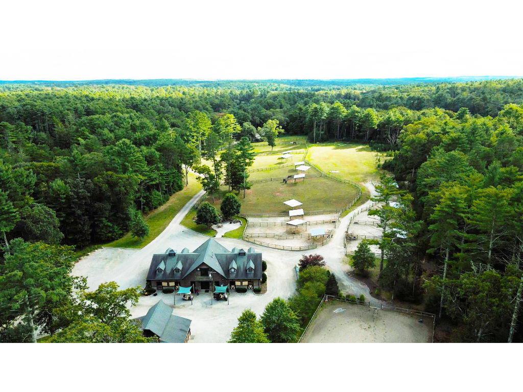 image Expansive aerial view of the property, showcasing the lush greenery, multiple structures, and spacious grounds.