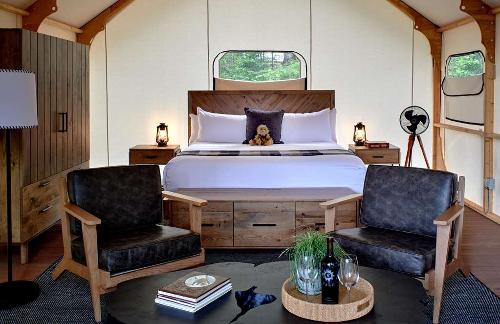 image Cozy glamping interior with king bed and plush seating and a warm ambiance, perfect for relaxation.