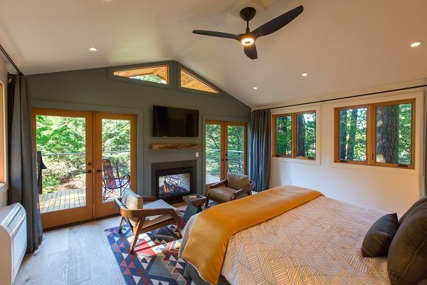 image Spacious and sunlit bedroom with panoramic windows offering stunning nature views.