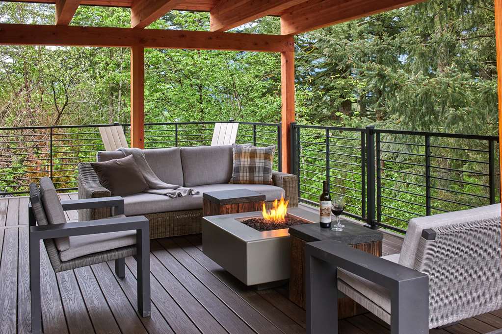 image Relax on the expansive deck with stylish outdoor furniture and stunning forest views.