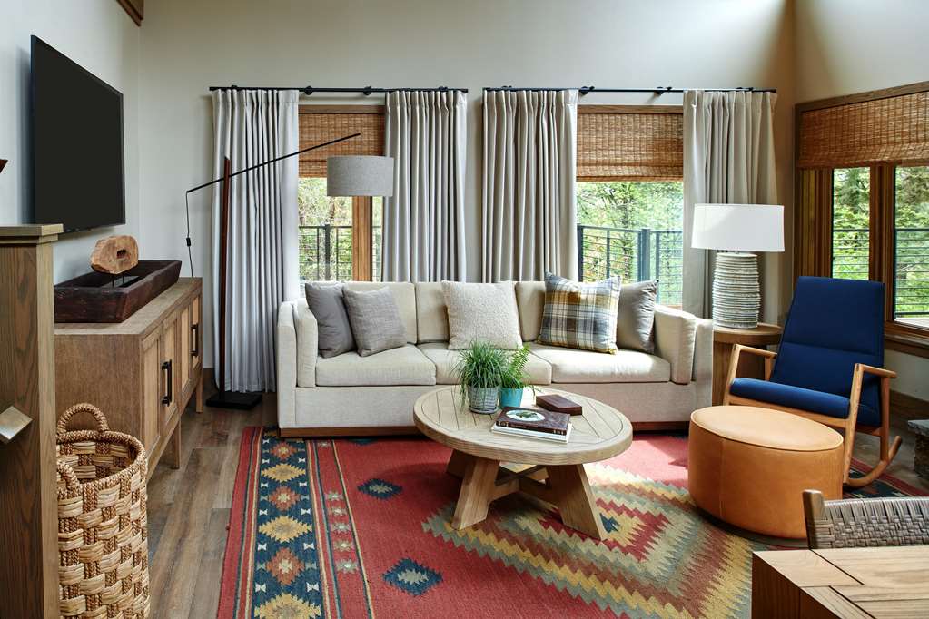 image Inviting living room with comfortable seating and large windows overlooking the greenery.