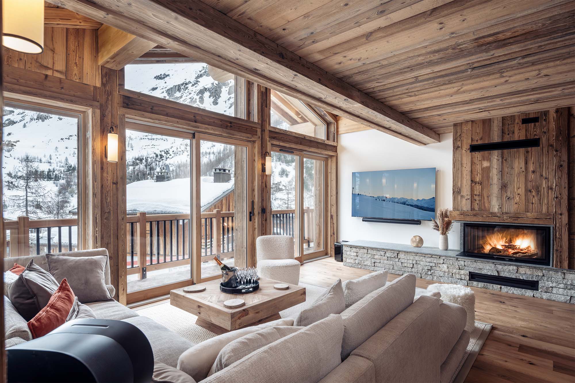 image Relax in this spacious living room featuring a cozy fireplace, large windows with breathtaking mountain views, and comfortable seating perfect for unwinding after a day on the slopes.