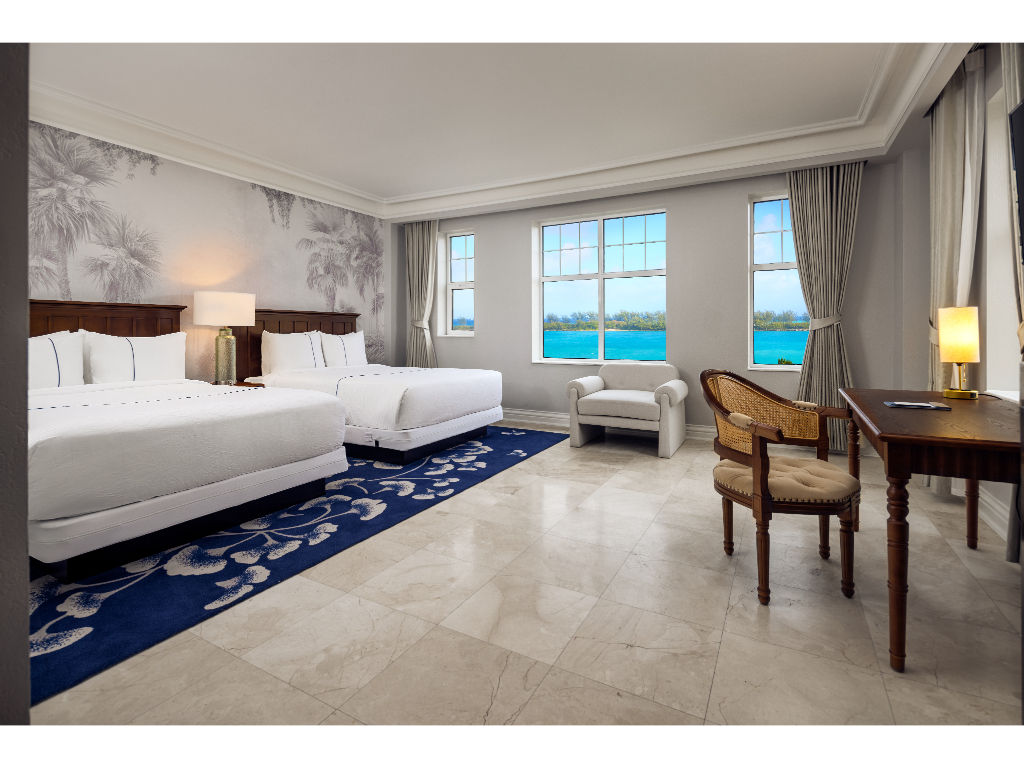 image Expansive room with two plush beds and a stunning ocean view.