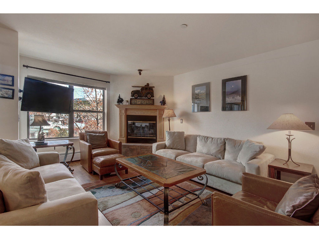 image Bright and airy living room with comfortable seating, a fireplace, and large windows for natural light.