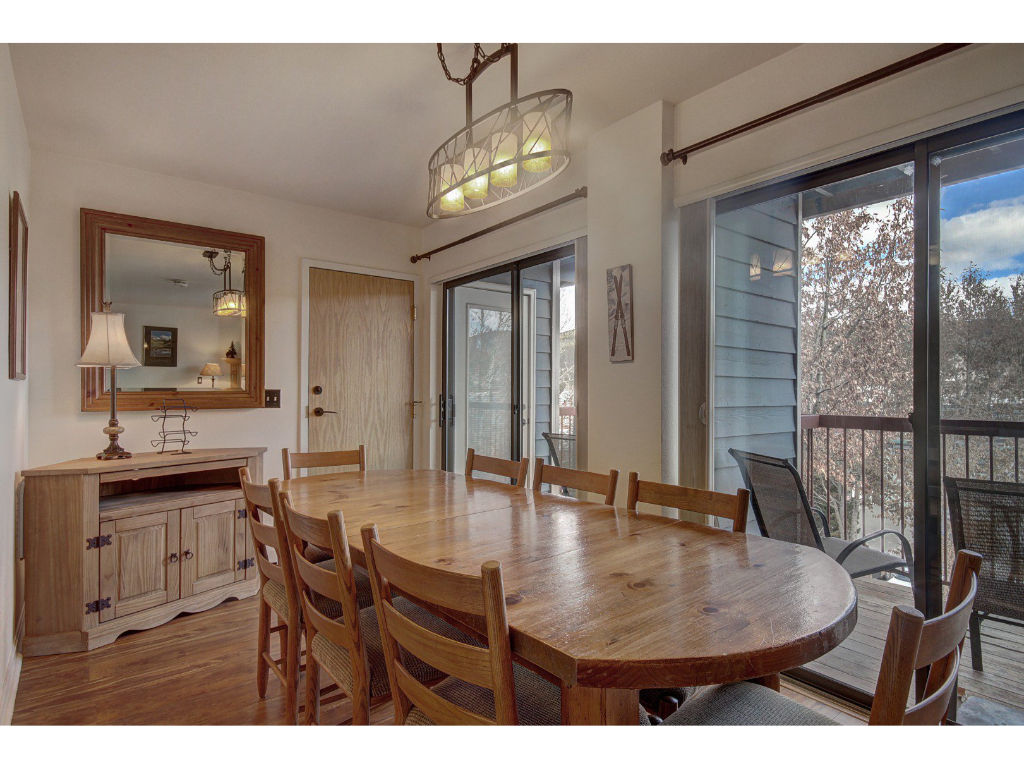 image Elegant dining area with a large wooden table and easy access to the balcony, ideal for family meals.