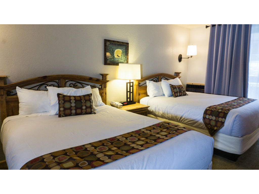 image Enjoy a restful night's sleep in these cozy twin beds, complemented by modern decor and soft lighting.