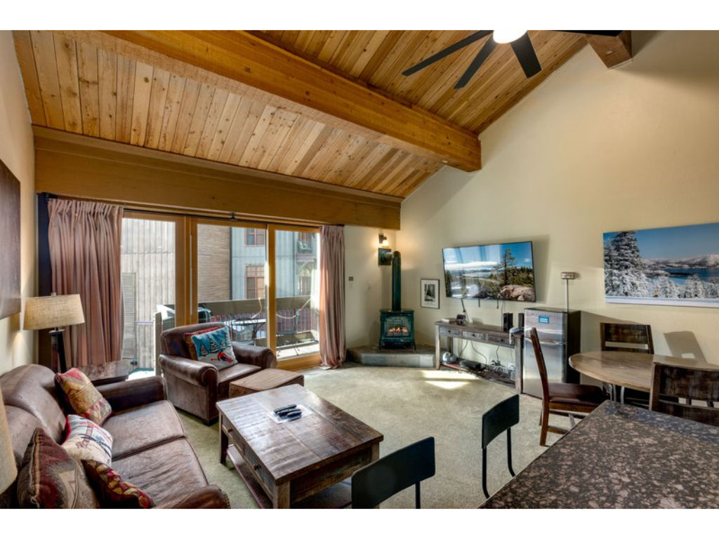 image Relax in the bright living area, boasting large windows, comfortable seating, and a stunning mountain view.