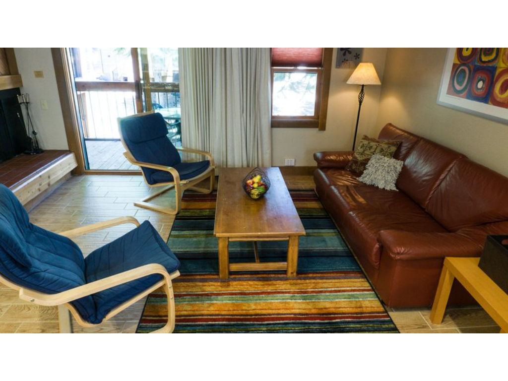 image Spacious living room filled with natural light, offering cozy seating and a warm, welcoming atmosphere.