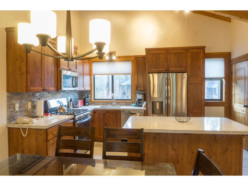 image Fully-equipped kitchen with modern amenities, ample counter space, and wooden cabinets, ideal for preparing delicious meals.