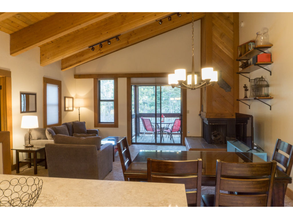 image Open-plan dining and living area, featuring a large dining table, comfortable seating, and a warm, inviting atmosphere.