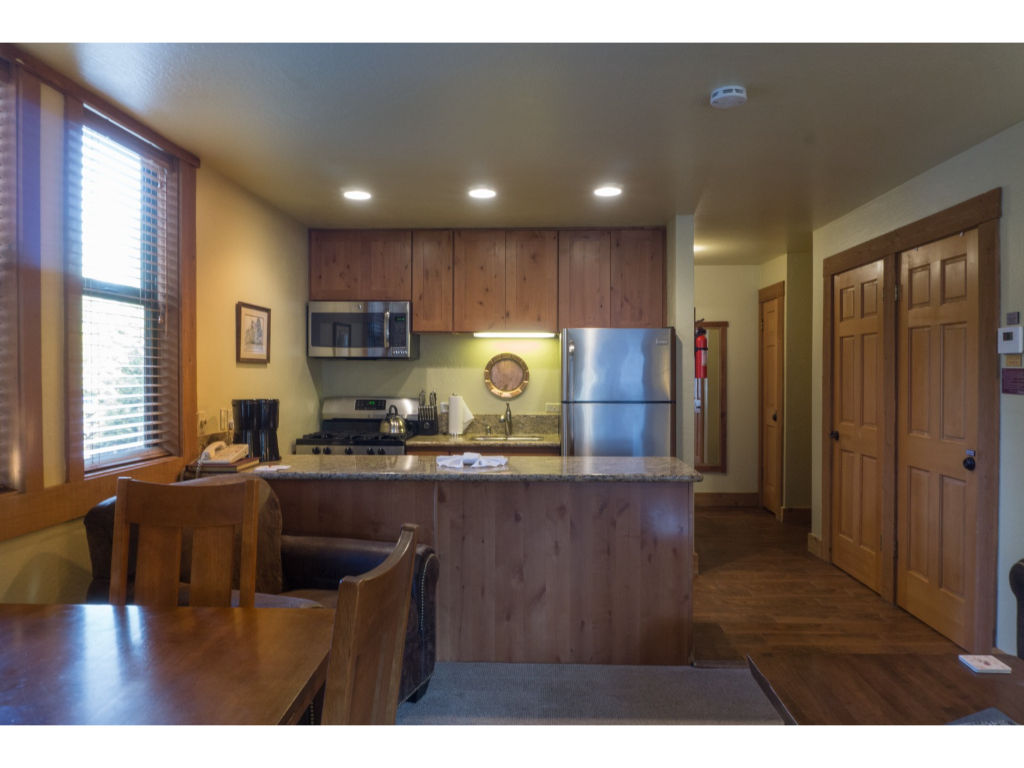 image Open-concept living and dining area with wooden furniture, perfect for gatherings and meals.