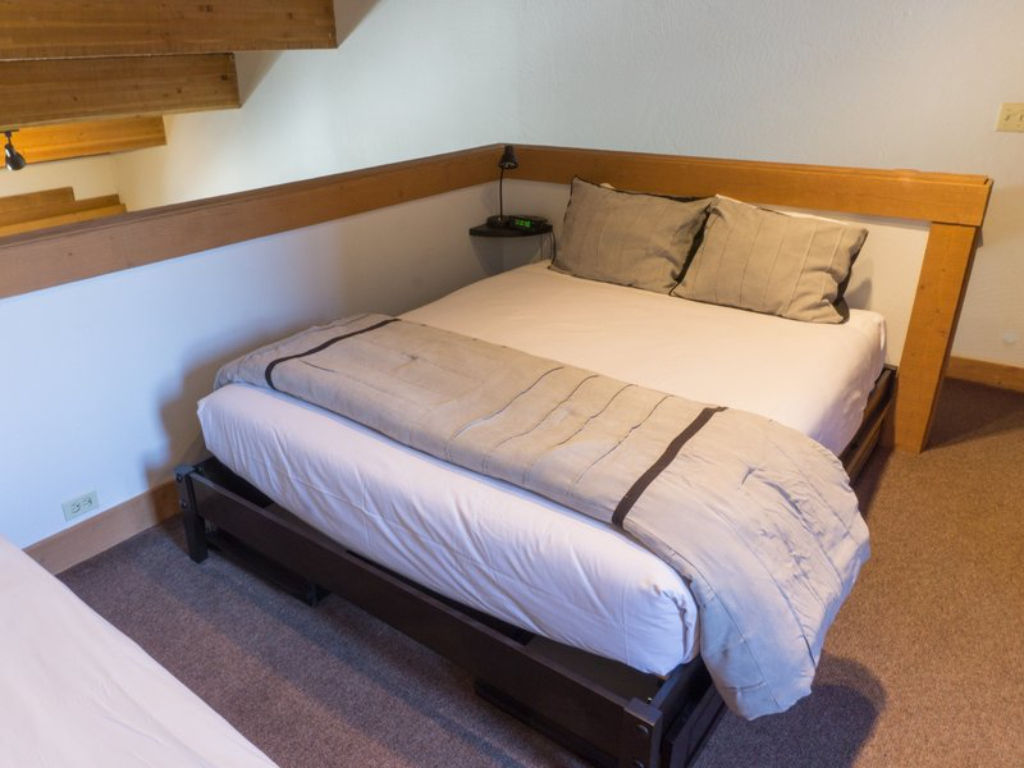 image Enjoy a restful night's sleep in this cozy bedroom nook, featuring a rustic design and comfortable bedding.