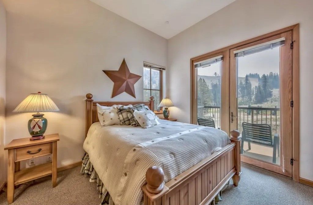 image Wake up to beautiful views in this charming bedroom featuring a cozy queen bed, warm decor, and large windows that let in plenty of natural light.