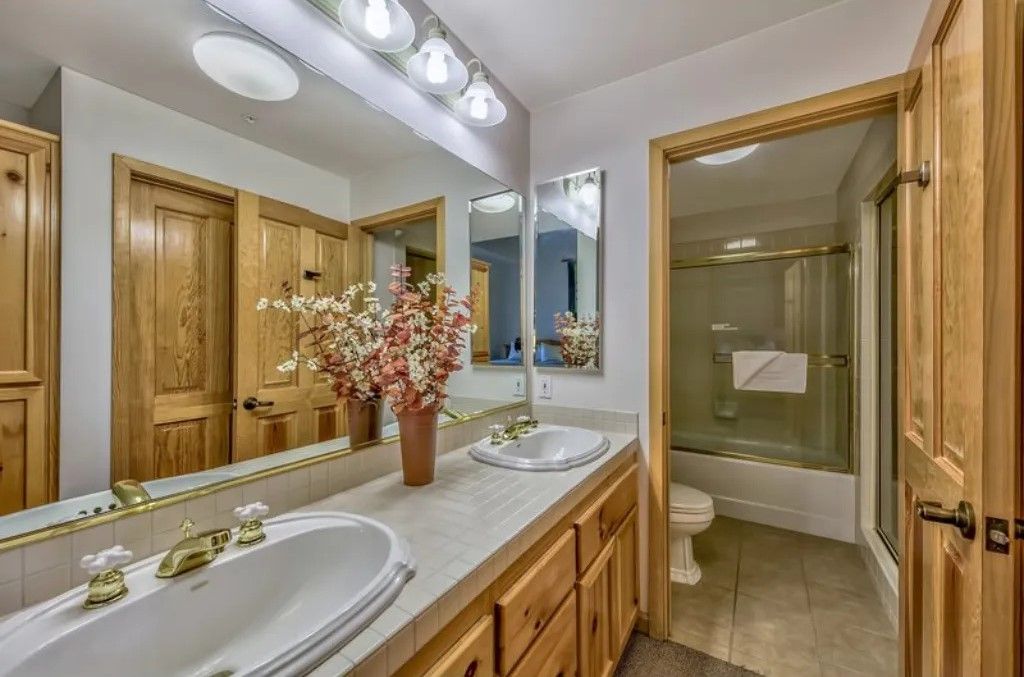 image Freshen up in this bright bathroom, which includes a large vanity with ample counter space, a well-lit mirror, and a shower/tub combo.