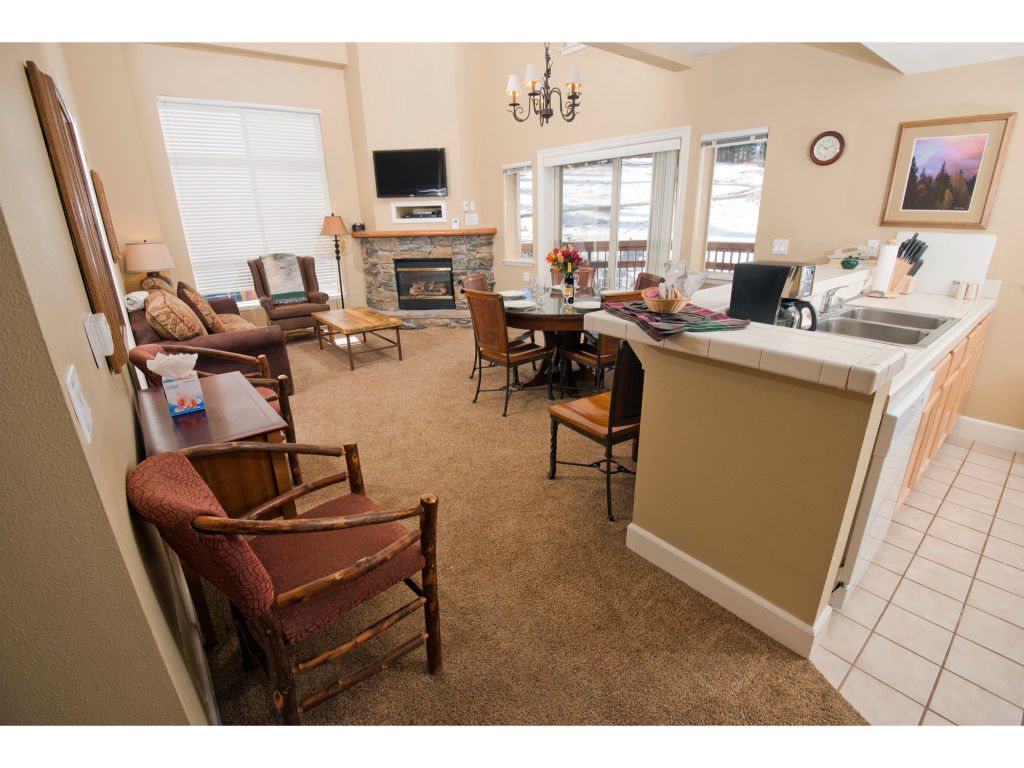 image This open living area and kitchen combo offers a cozy sitting space, a dining area, and a fully equipped kitchen, ideal for entertaining and family gatherings.