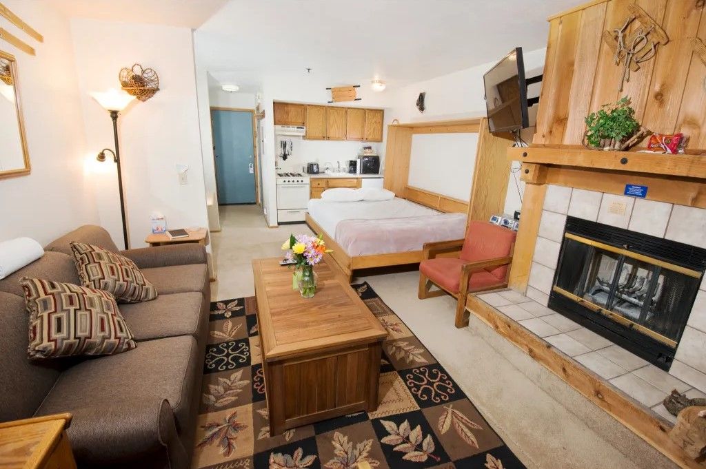 image Enjoy this charming studio that combines a living area, a sleeping space with a comfy bed, and a fireplace, perfect for a cozy retreat.