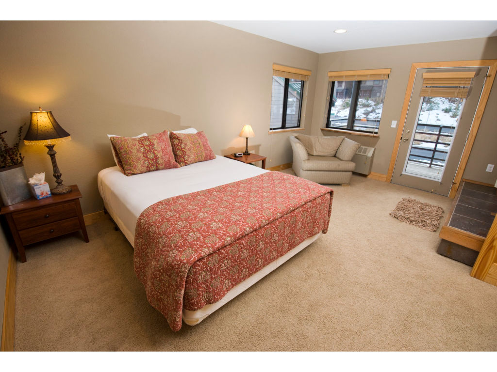 image Rest easy in this comfortable bedroom featuring a plush queen bed, stylish bedding, and ample storage space.