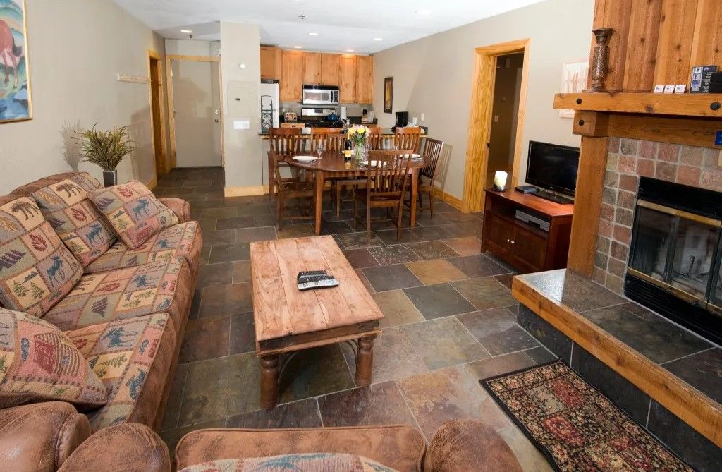 image Enjoy cozy evenings in this spacious living room, complete with a fireplace, comfortable seating, and a rustic coffee table.