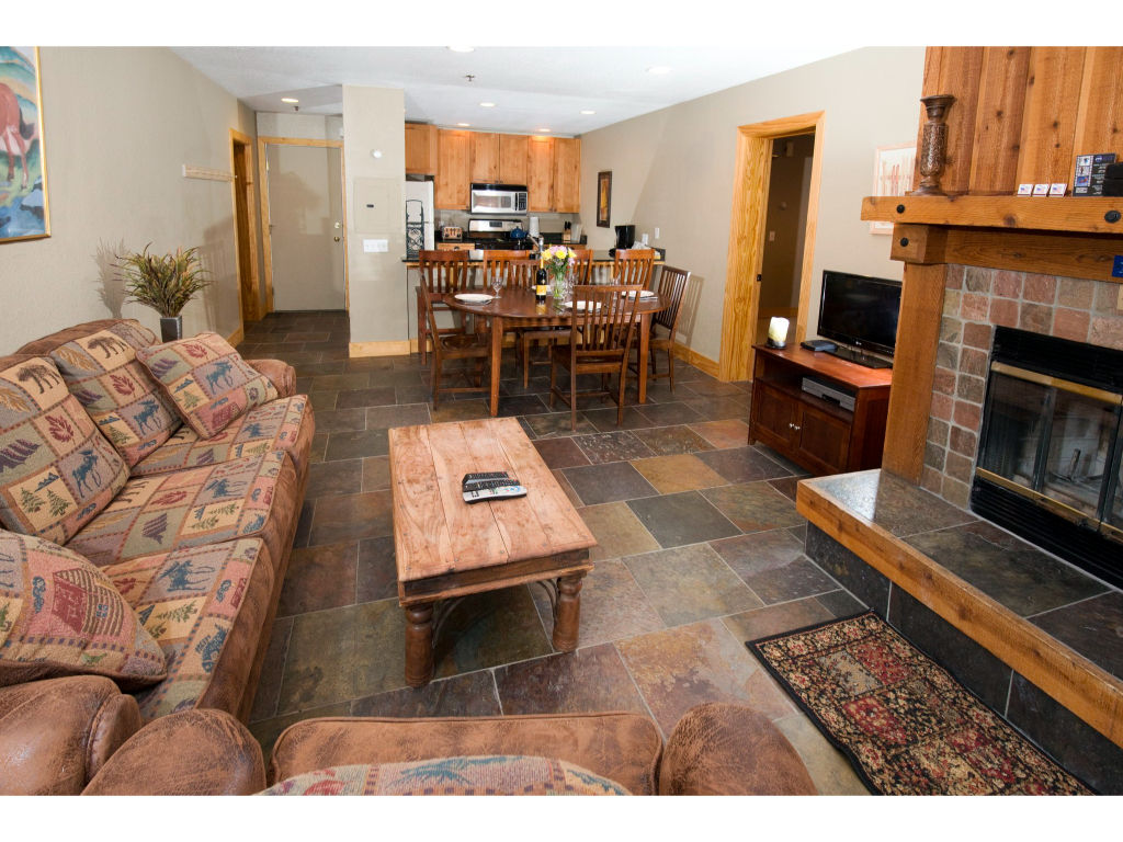 image Enjoy cozy evenings in this spacious living room, complete with a fireplace, comfortable seating, and a rustic coffee table.