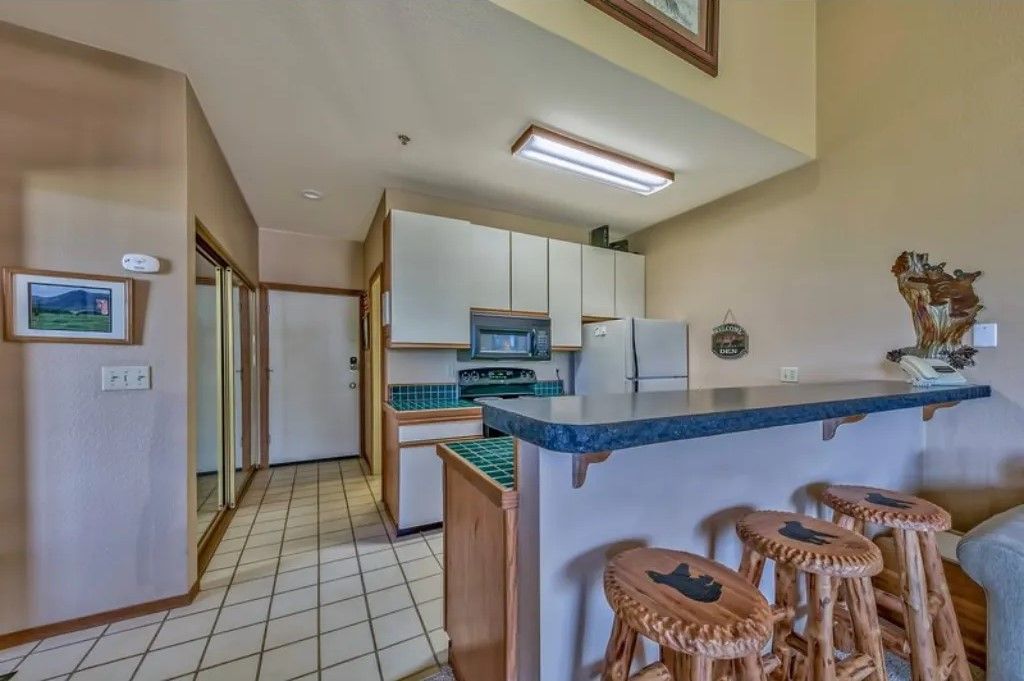 image Prepare and enjoy meals in this open-concept kitchen and dining area with modern appliances, a spacious layout, and bar seating.