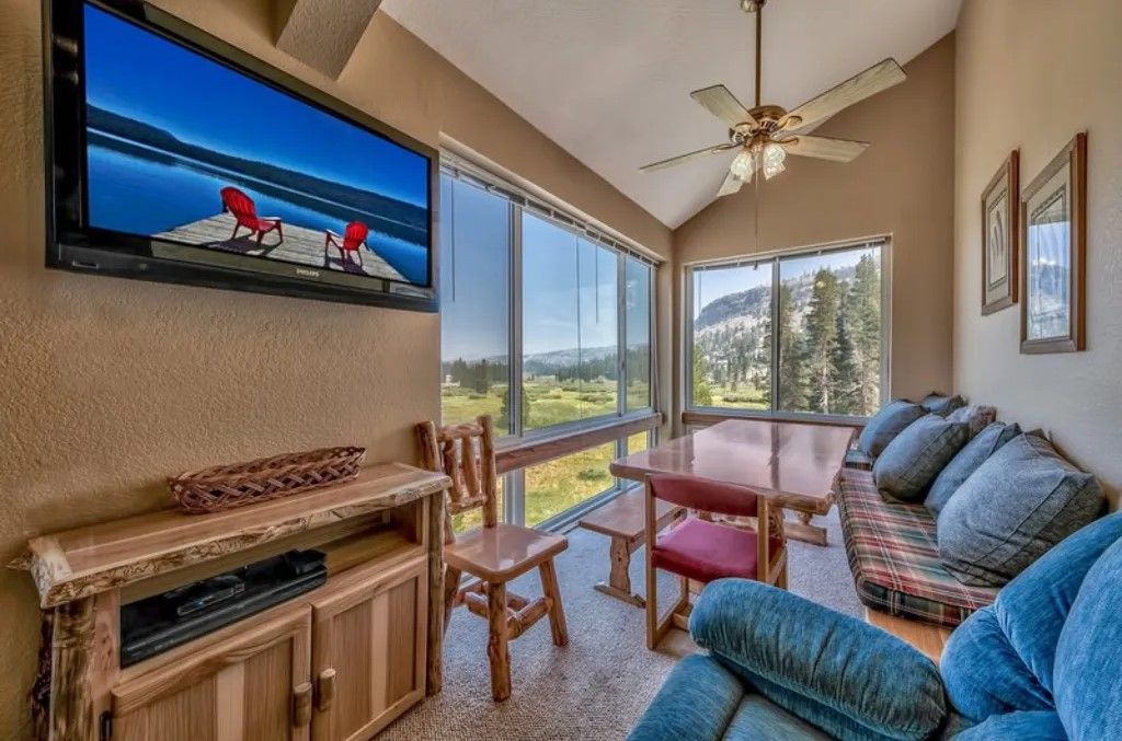 image Unwind in this cozy living room featuring comfortable seating, a TV, and views of the surrounding landscape.