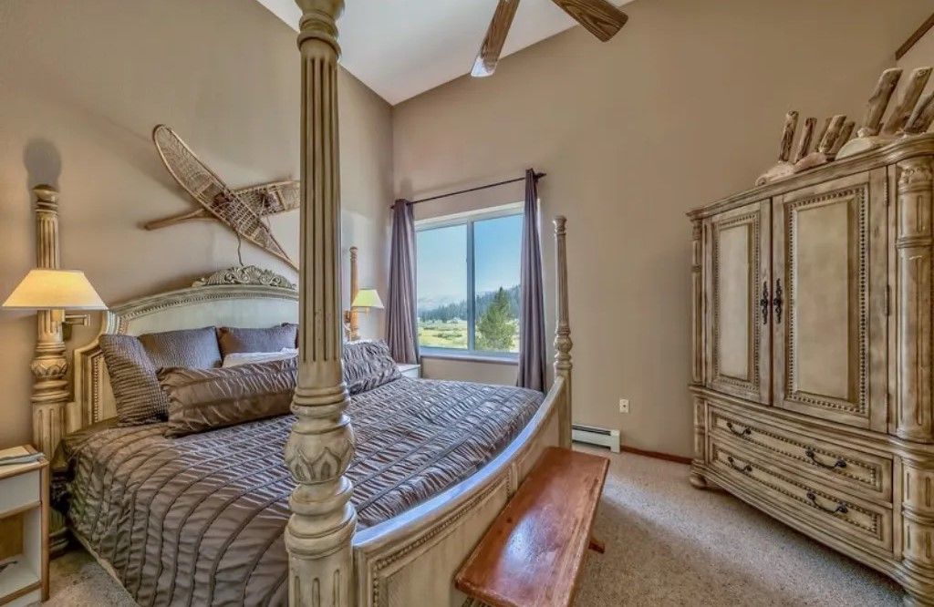 image Sleep in style in this elegant master bedroom with a luxurious four-poster bed, antique furnishings, and large windows for plenty of natural light.