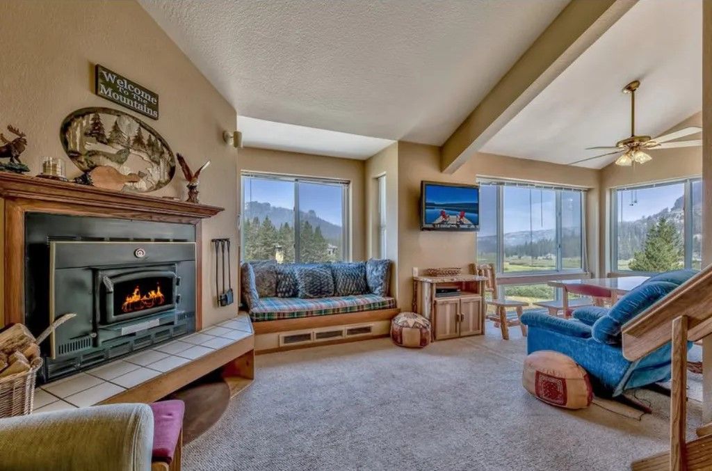 image Gather around the fireplace in this inviting living area, complete with plush furniture and expansive windows showcasing stunning outdoor views.