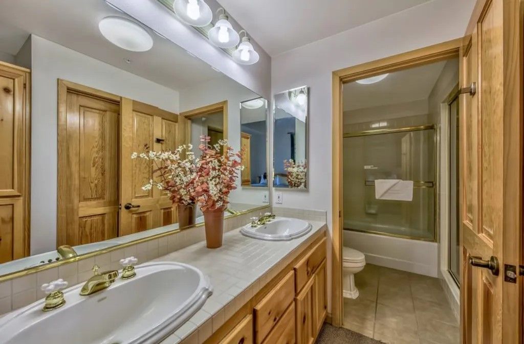 image Enjoy the bright and clean bathroom equipped with a large vanity, plenty of storage, and a refreshing shower.