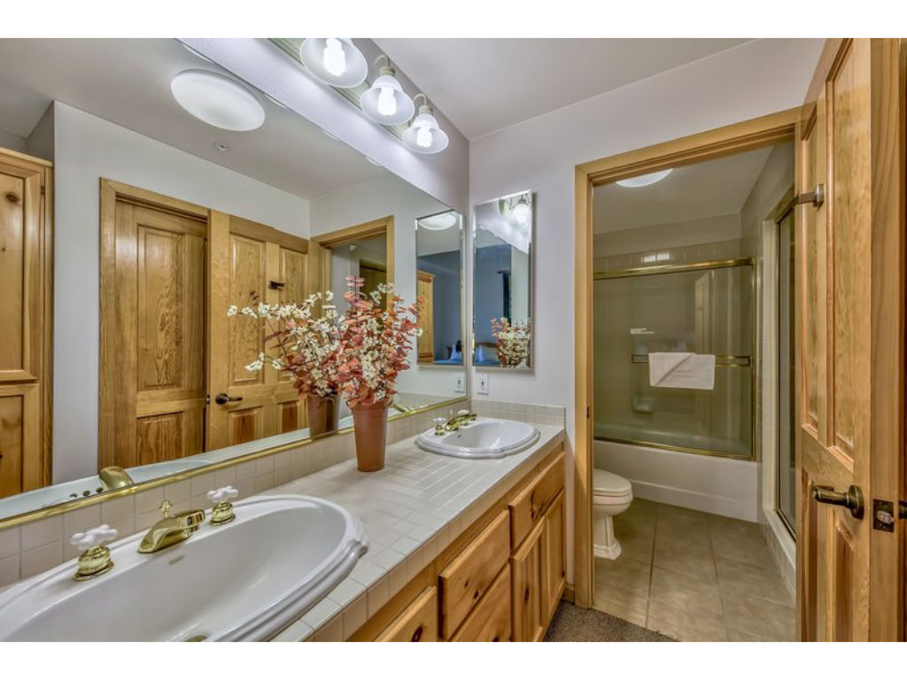 image Enjoy the bright and clean bathroom equipped with a large vanity, plenty of storage, and a refreshing shower.