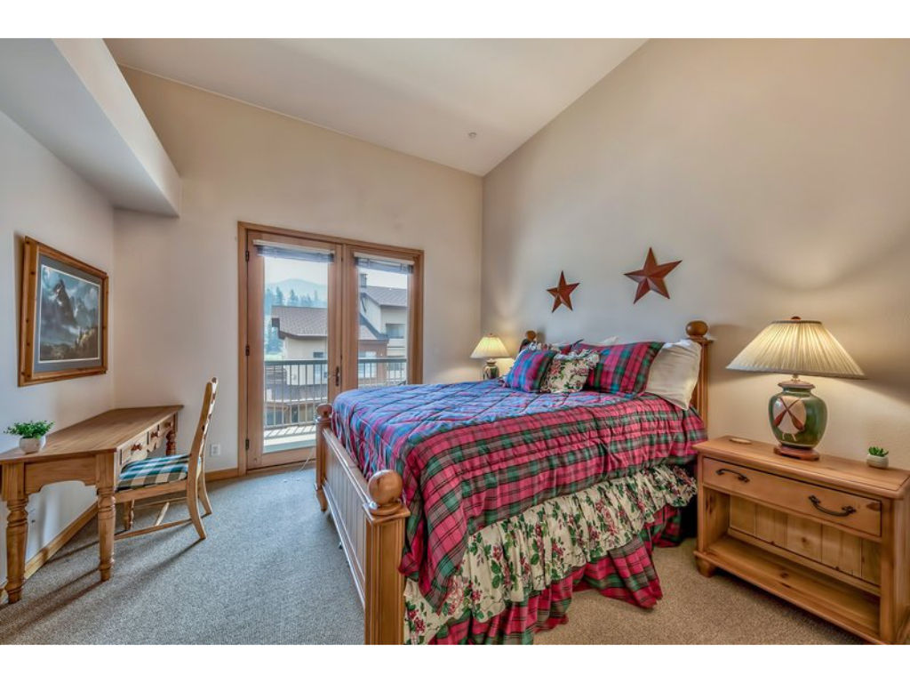 image This warm and inviting bedroom offers a queen bed, traditional wooden furniture, and beautiful natural light from large windows.