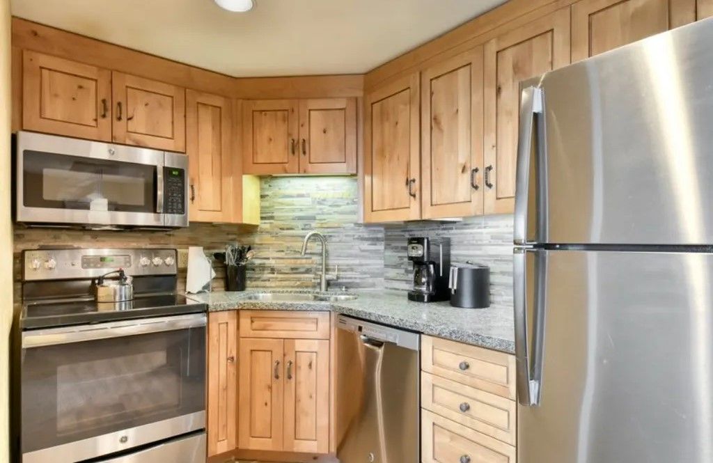 image Well-equipped kitchen with stainless steel appliances and wooden cabinets.
