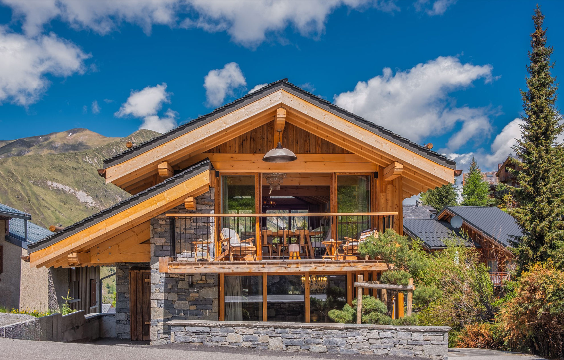 image Experience the charm of alpine living in this stunning chalet, featuring expansive windows and a spacious balcony that offer breathtaking mountain views.