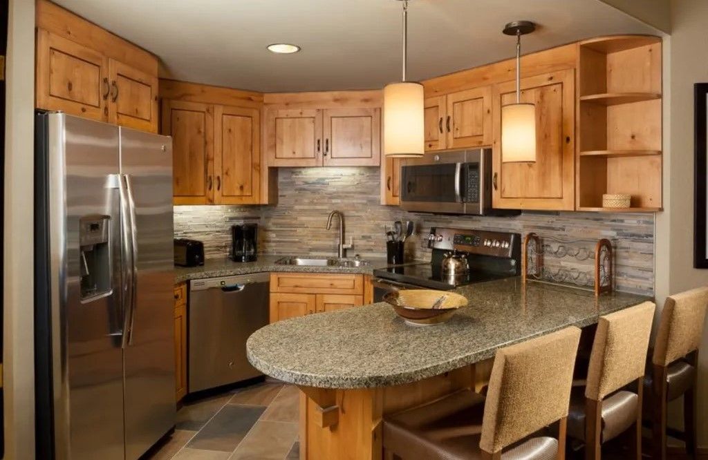 image Fully equipped kitchen with modern appliances and a breakfast table.