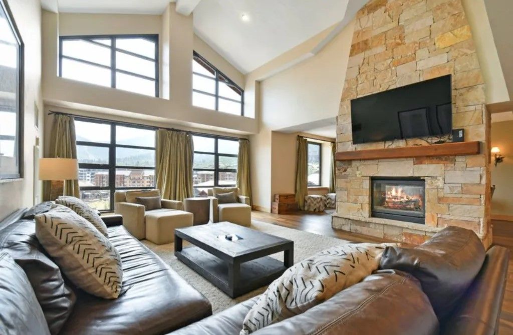 image Cozy living room with a stone fireplace and plush seating.