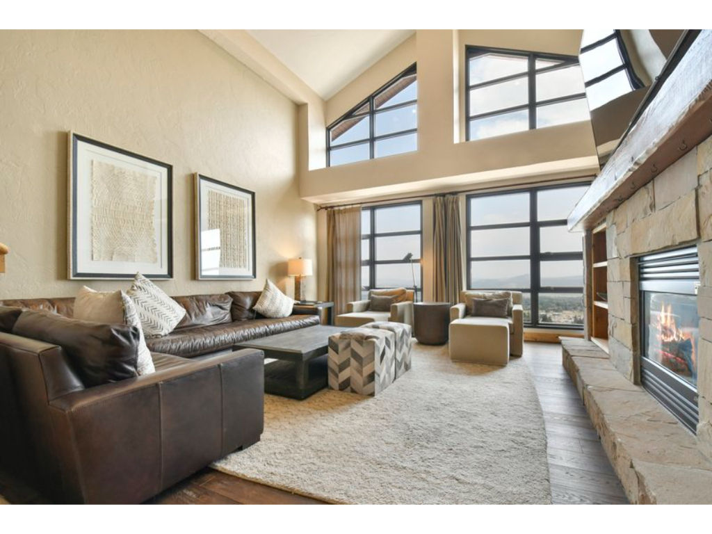 image Spacious living area with large windows and vaulted ceilings.