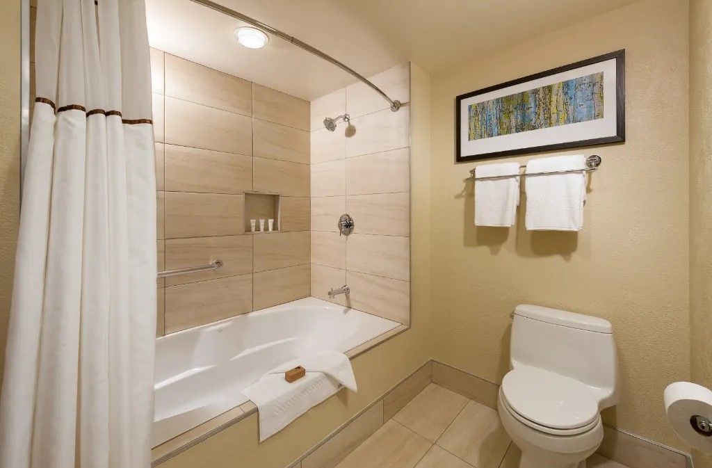 image Contemporary bathroom with a full tub and elegant finishes.