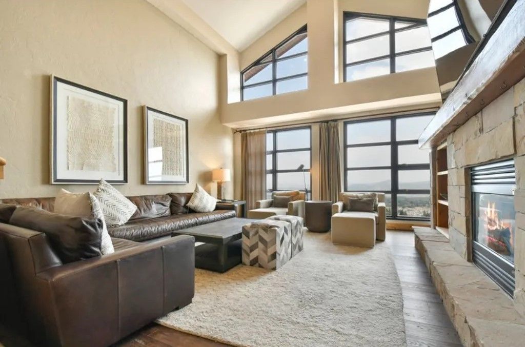 image Spacious living area with large windows and vaulted ceilings.