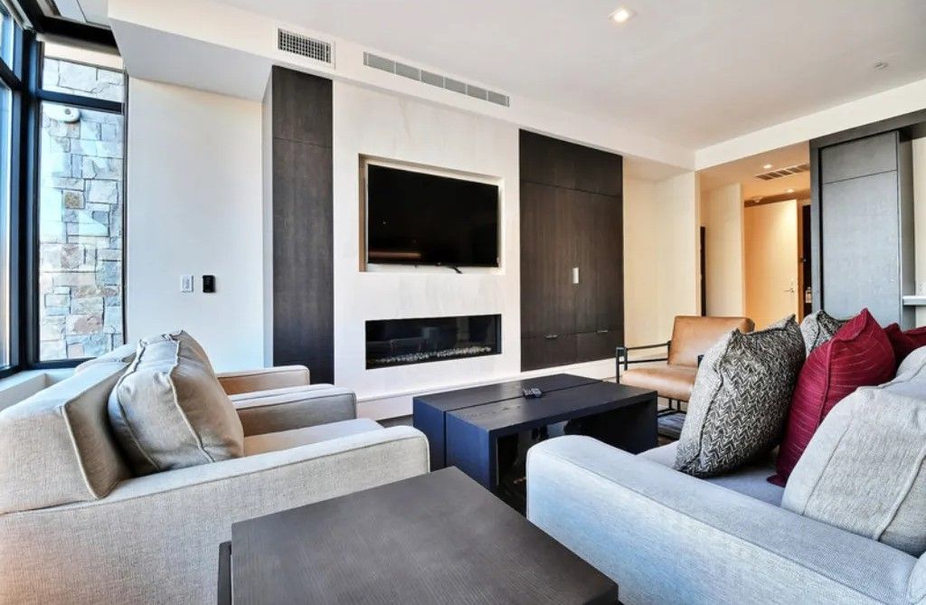 image Cozy living room with a fireplace and large windows.