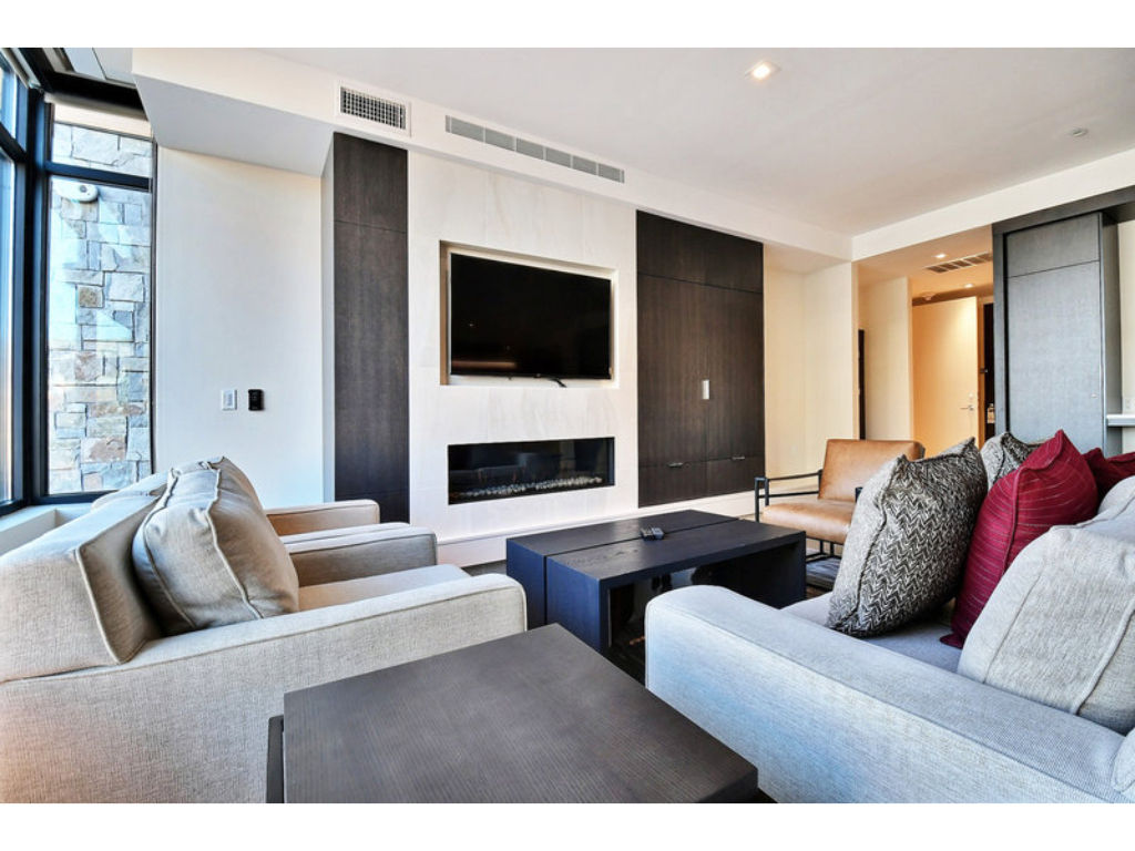 image Cozy living room with a fireplace and large windows.