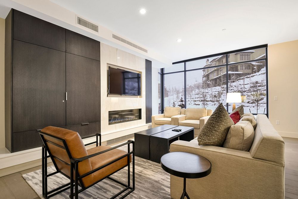 image The spacious living room, adorned with elegant furnishings, provides a warm and inviting space to unwind while enjoying breathtaking mountain views.