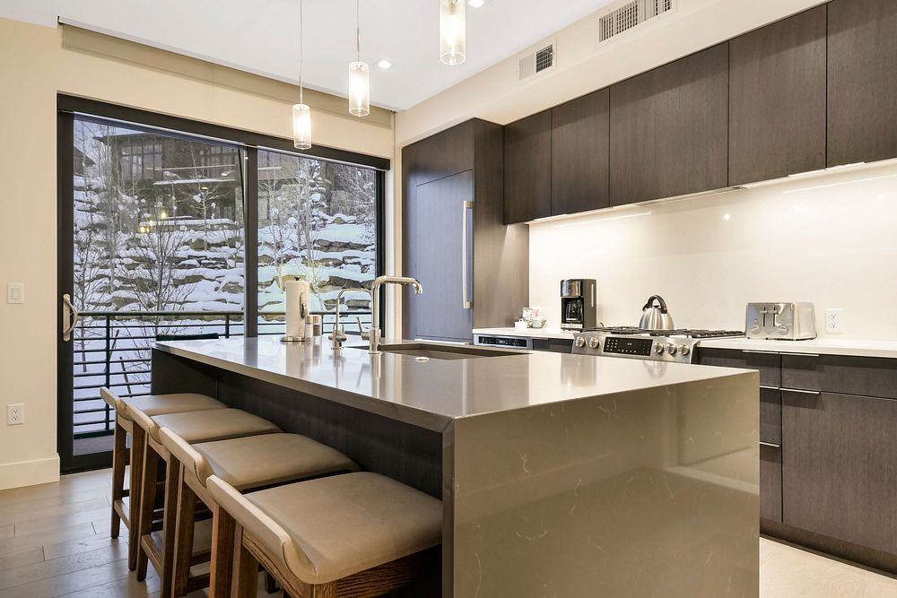 image The modern kitchen boasts a spacious island with seating, perfect for family gatherings or casual meals.