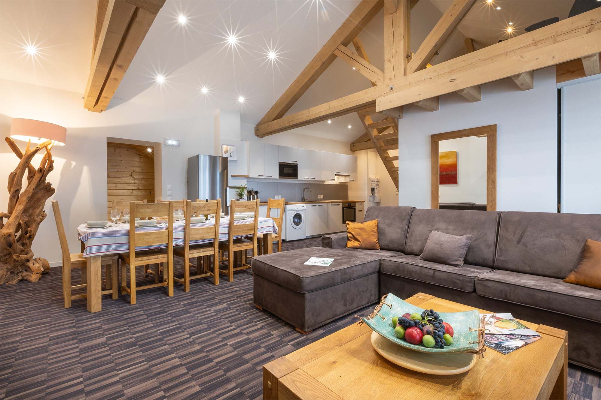 image This open-plan living room features plush seating, high wooden ceilings, and rustic decor, creating a cozy and welcoming atmosphere for relaxing or socializing with family and friends.